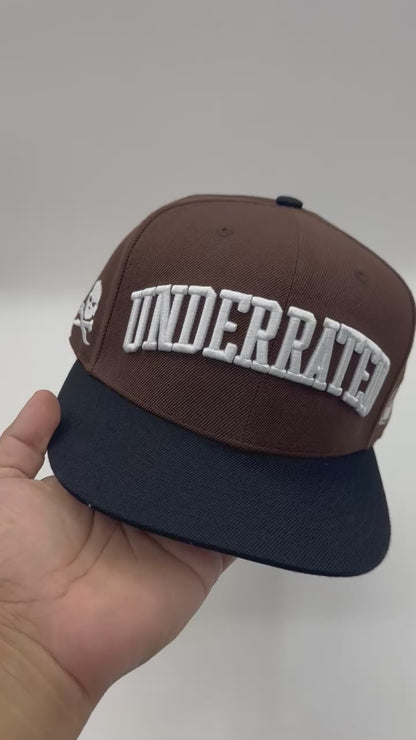 “Underrated” Snapback Cap – Brown / Black by KRWN