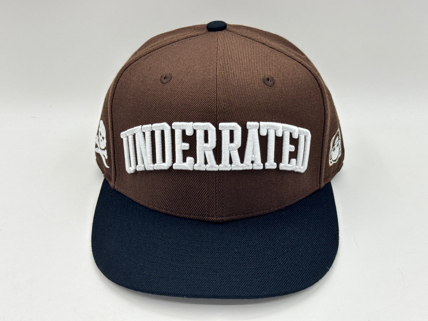 “Underrated” Snapback Cap – Brown / Black by KRWN