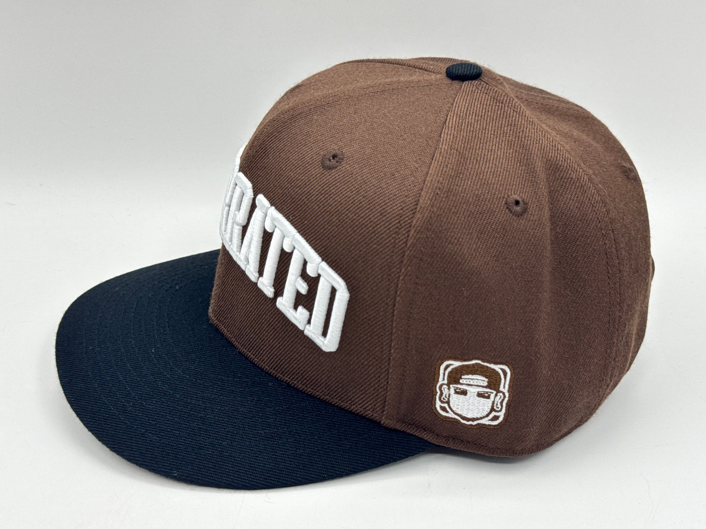 “Underrated” Snapback Cap – Brown / Black by KRWN